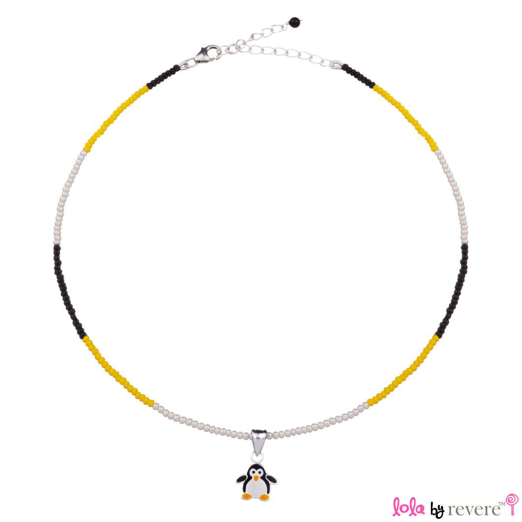 Children's silver penguin pendant delicately suspended on a string of black,yellow and white glass crystals. 