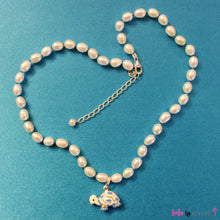 Load image into Gallery viewer, White freshwater pearls handknotted with blue thread with a blue and white tortoise pendant delicately suspended. Add some blue to any outfit.The necklace measures 14&quot; with an adjustable chain of 2&quot; to increase length to 16&quot;.
