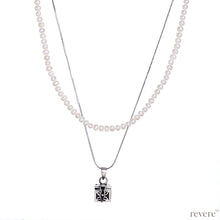 Load image into Gallery viewer, Dive into the magical temptation of this stunning Budhhist box pendant in attractive design made of sterling silver.The neckpiece features a 2 strand design, one strand of white pearls and a second of sterling silver chain and a beautiful Budhhist pendant in sterling silver.
