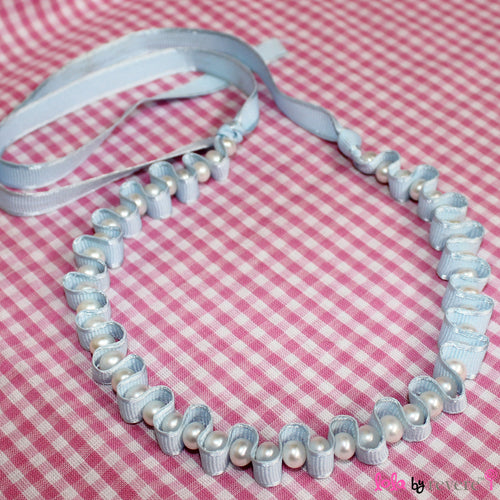 Delicate freshwater water pearls woven into satin ribbon for a royal yet dainty effect. This piece measures 12