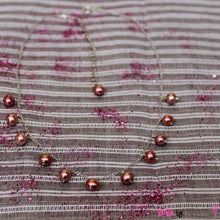Load image into Gallery viewer, Metallic red freshwater pearls delicately scattered on a sterling silver chain with rhodium plating. Ideal pearls for a 13th or 16th birthday present.
